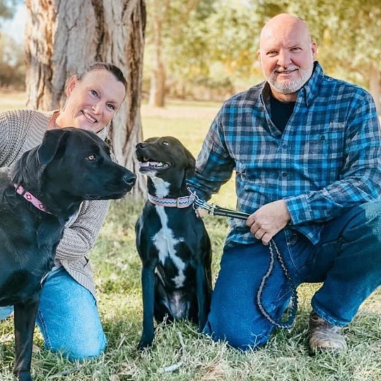 Portrait photo of the Lazy Acres Owners and their dogs